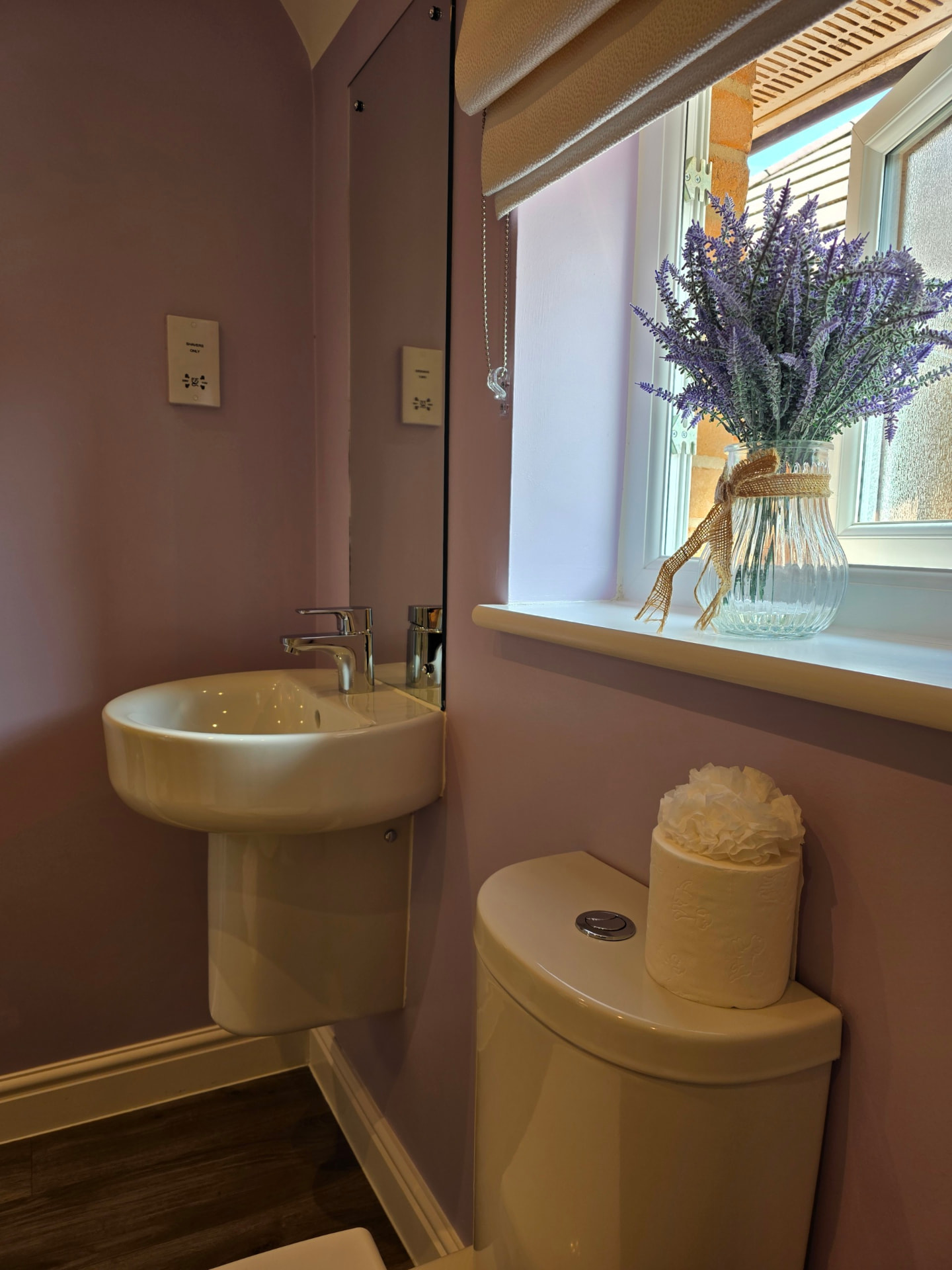 Sparkling cloakroom basin with fresh flowers on the windowsill