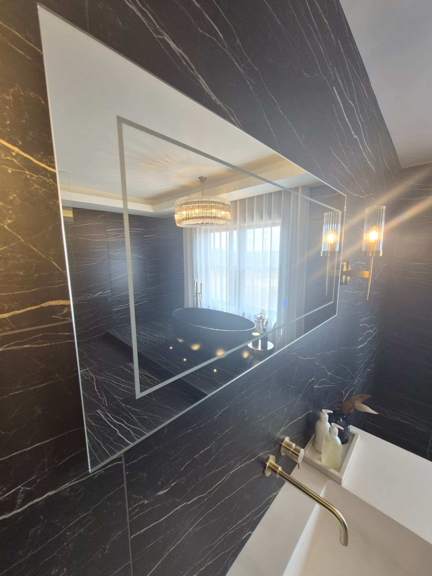 Polished marble bathroom with streak-free mirror and freestanding bath